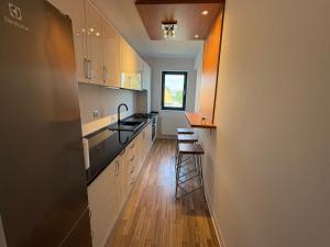 a kitchen with white cabinets and a counter top at Apartament Luxury nino in Focşani