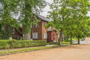a brick house with trees in front of it at Where Classic Charm Meets Modern Serenity in Pittsburgh