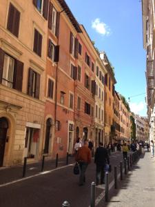 un grupo de personas caminando por una calle con edificios en Boschetto 124 Apartment, en Roma