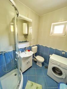 a blue tiled bathroom with a toilet and a sink at Apartments Dosljak in Tivat +25 photos