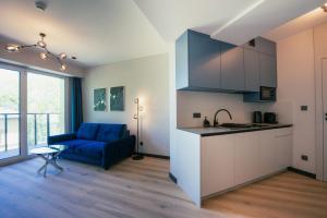 a kitchen and living room with a blue couch at AboutArtApartments - Krzywoustego in Wrocław