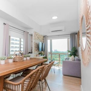 ein Wohnzimmer mit einem Holztisch und Stühlen in der Unterkunft Julias Tropical Oasis Golf Skyline View in Manila
