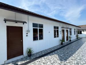 a white building with a brown door and windows at D' Ehsan Homestay & Chalet in Kuala Terengganu