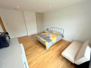 a bedroom with a bed and a couch at Studio (Triple) in Sutton in Cheam