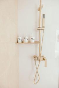 a bathroom with a shelf with toiletries on it at Modern Coastal Design 1 BR Condo Golf View BGC in Manila