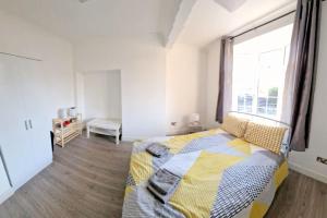 ミッチャムにある6-bedroom House in Morden, London (Zone 4)のベッドと大きな窓のある寝室