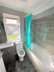 ミッチャムにある6-bedroom House in Morden, London (Zone 4)のトイレ、浴槽、洗面台を備えたバスルーム