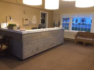 a lobby with a reception counter and a waiting room at Holiday Hill Inn & Suites in Dennis Port