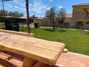 un banco de madera en un patio con patio en Duo SPA Provence, en Violès