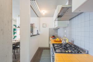 a kitchen with a stove and a yellow counter top at Casa Corbu by Rent All Como in Blevio +32 photos