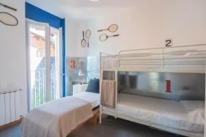 a bedroom with two bunk beds and a window at Casa Corbu by Rent All Como in Blevio