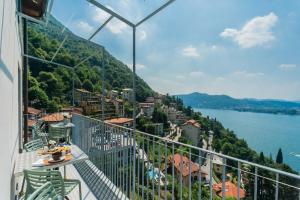 a balcony with a view of a city and water at Casa Corbu by Rent All Como in Blevio