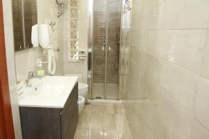 a bathroom with a shower and a sink and a toilet at B&B Maestra Giovanna in Pompei