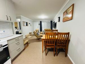 a kitchen and dining room with a table and chairs at Nestled next door in Stanthorpe