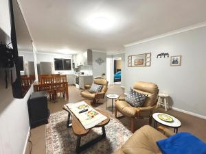 a living room with a couch and chairs and a table at Nestled next door in Stanthorpe