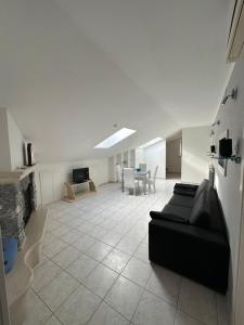 a living room with a black couch and a table at La Casa Di Betta, Natura e Relax in Piana di Forcella