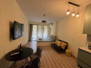 a living room with a table and a couch at Bamboo beach tsikhisdziri in Kobuleti