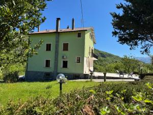 a large green building in the middle of a field at CASA DI BETTA Appartamento 3 Ascoli, Norcia, Monti Sibillini in Piana di Forcella
