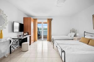 una camera d'albergo con due letti e una televisione di Boutique Guesthouse Sveti Petar, on the beach, heated pool & boat berth - ADULT ONLY a Nečujam