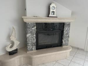 a fireplace with a clock on top of it at CASA DI BETTA Appartamento 3 Ascoli, Norcia, Monti Sibillini in Piana di Forcella
