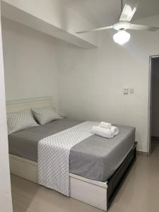 a white bedroom with a bed with a ceiling at Plataview Apartahotel 3B in Monte Plata