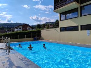 Tres personas están nadando en una piscina en Da NOEMI E MARCO, en Cavalese