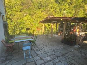 a patio with a table and chairs and a pavilion at Appartamento Falesia del Neirone in Gavi