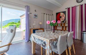 a dining room with a table and chairs and a window at Villa Piscine Privée in La Roquette-sur-Siagne