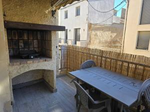 a table and chairs on a patio with a fireplace at "L'évasion les pieds dans le sable" Magnifique appartement bord de Mer in Le Grau-du-Roi