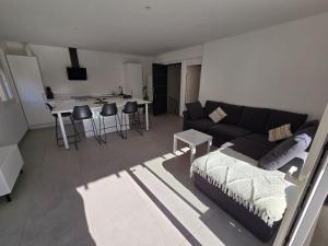 a living room with a couch and a table at Vue Mer avec Terrasse Calme & Confort Moderne in Le Grau-du-Roi