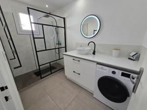 a bathroom with a sink and a washing machine at Vue Mer avec Terrasse Calme & Confort Moderne in Le Grau-du-Roi +23 photos