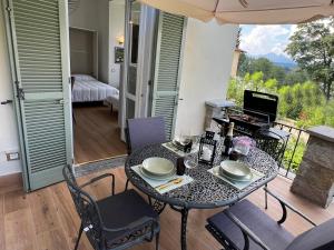 a table with chairs and an umbrella in a room at Stresa Golf & Relax Romantik Suite in Gignese