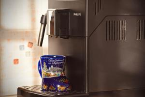 a blue cup sitting on a counter next to a refrigerator at Orsi House in Szombathely