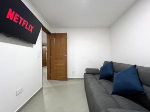 a living room with a couch and a sign on the wall at Apartamento Florelba - a dos cuadras del parque in Carmen de Viboral