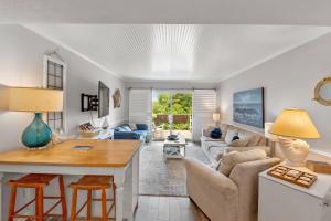 una sala de estar con una mesa y un sofá en Villas J2, en Nags Head