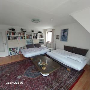 een woonkamer met twee bedden en een tafel bij Ferienwohnung GOMO in Stockelsdorf