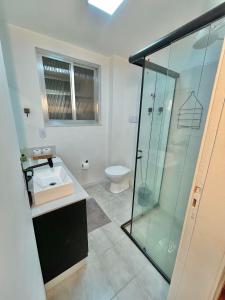 a bathroom with a glass shower and a toilet at Apartamento completo 3min do Friburgo Shopping in Nova Friburgo +14 photos