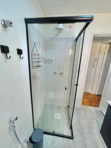 a shower with a glass door in a bathroom at Apartamento completo 3min do Friburgo Shopping in Nova Friburgo