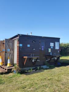a tiny house sitting in a yard next to a fence at Monroe Horsebox Glamping in Porthleven +15 photos