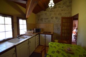 a kitchen with a sink and a table in it at Charmant pigeonnier à Dondas - Clévacances 2 Clés in Dondas