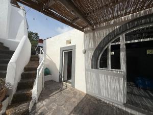 a entrance to a white building with a door and stairs at House La Pennata - sea view in Malfa
