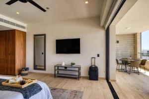 a bedroom with a bed and a television on a wall at Group Apt 13 16, no view, 3BR, 12 pax in Cabo San Lucas