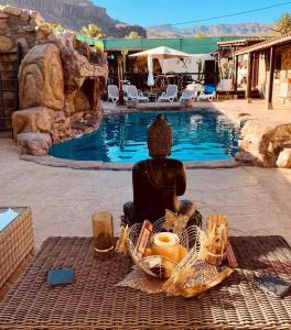 a buddha statue sitting on a blanket next to a pool at Angels Pathway in Fátaga