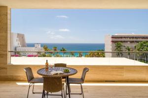 a table and chairs on a balcony with a view of the ocean at For couples, petfriendly 2 BR ocean view 18 4pax in Cabo San Lucas