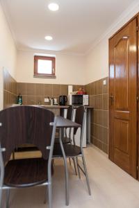 a kitchen with a table and chairs in a room at Dorottya Vendégház in Hódmezővásárhely