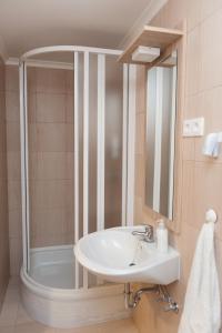 a bathroom with a sink and a shower at Dorottya Vendégház in Hódmezővásárhely +24 photos