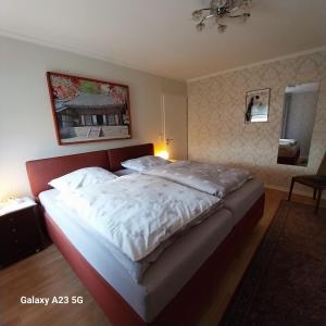 a bedroom with a large bed with white sheets at Ferienwohnung GOMO in Stockelsdorf