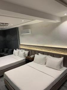 deux lits dans une chambre d'hôtel avec dans l'établissement Renaissance Hotels, à Islamabad