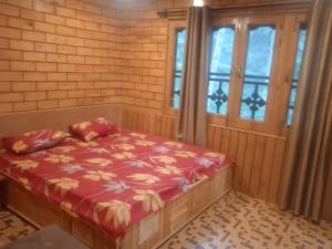 a bedroom with a bed in a room with windows at Cloud Culture Homestay in Dalhousie