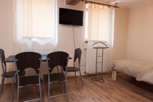 a room with a table and chairs and a bed at Dorottya Vendégház in Hódmezővásárhely